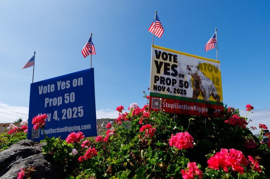 Signs supporting Proposition 50, aimed at countering Republican-led redistricting in Texas by redrawing California's congressional map to favor Democrats, are seen in a residential neighborhood in Encinitas, California, on September 29, 2025.