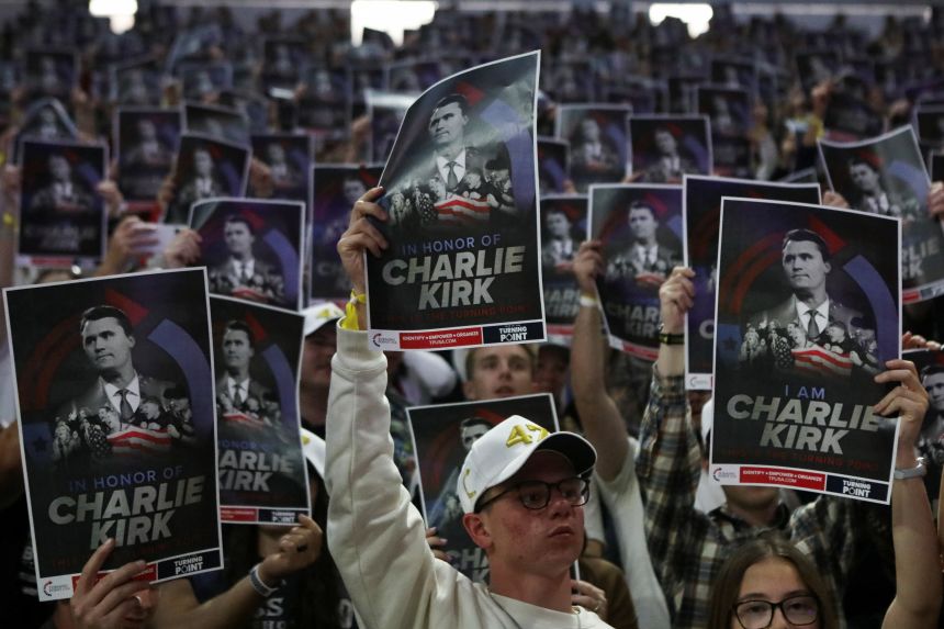 People hold posters with an image Charlie Kirk, at the Turning Point USA event in Logan, Utah, on Tuesday.