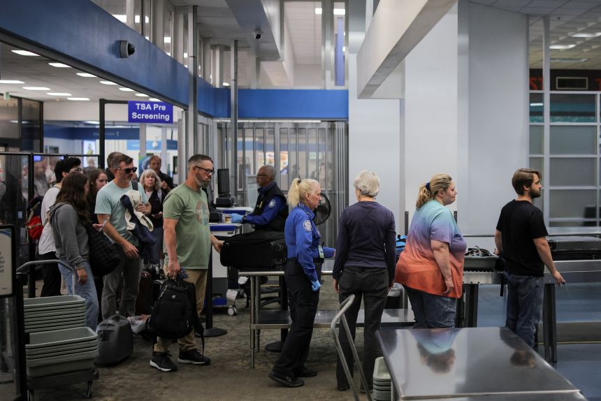 Travelers pass through a Transportation Security Administration security screening at Hollywood Burbank Airport during the first day of a partial US government shutdown on October 1.