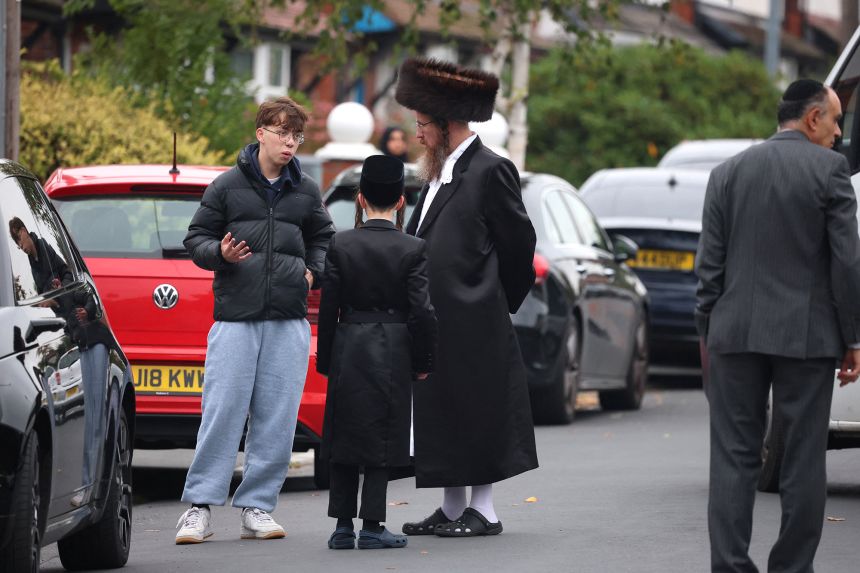 Worshipers gather near Heaton Park Hebrew Congregation Synagogue, northern England, after a car ramming and stabbing attack on the holiest day of the Jewish calendar.
