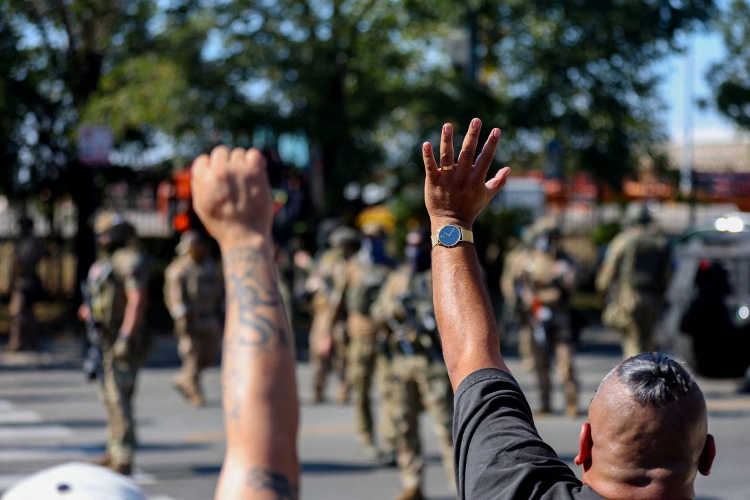 Demonstrators gesture during a standoff with ICE and federal officers in the Little Village neighborhood of Chicago, Illinois, on October 4.