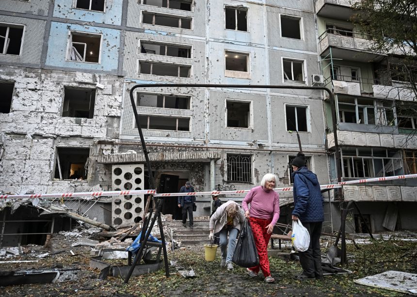 Residents leave their apartment building damaged by a Russian drone strike in Zaporizhzhia, Ukraine, on October 5, 2025.