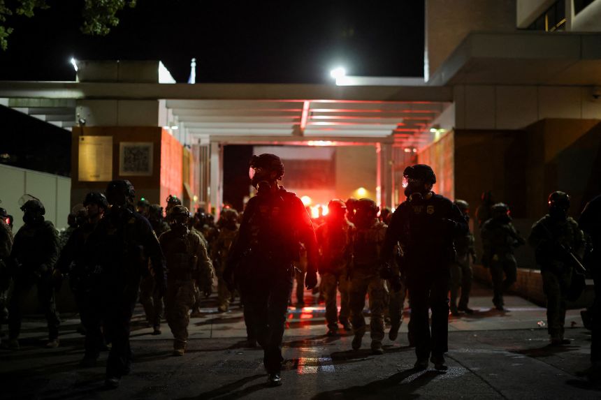Law enforcement officers disperse protesters outside the US Immigration and Customs Enforcement (ICE) headquarters in south Portland, Oregon, on October 5, 2025.