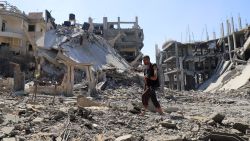 Palestinian man Jehad Al-Shagnobi, who was injured in an earlier Israeli strike on his house, walks with an external fixator on his arm to inspect the damage at his home in Sabra neighbourhood, following an Israeli operation, at Sabra neighbourhood in Gaza City, October 8, 2025.