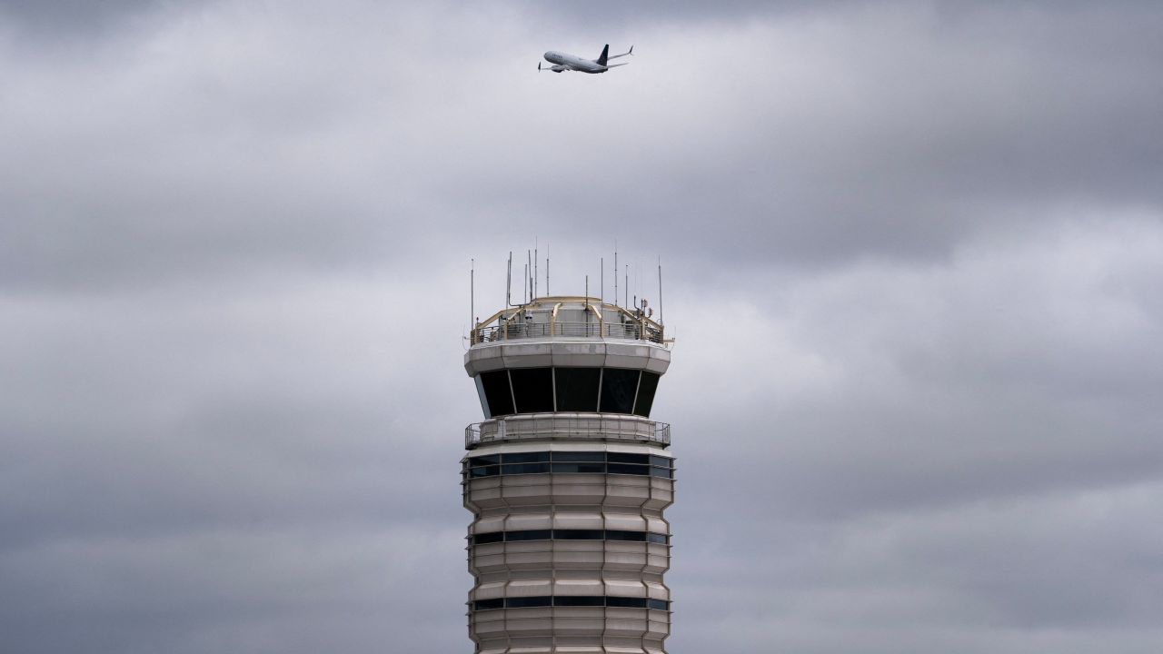A flight takes off past the air traffic control tower at Ronald Reagan Washington National Airport in Arlington, Virginia, on October 8.