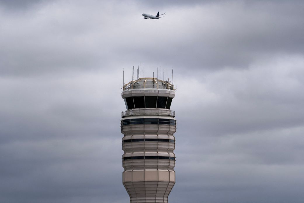 A flight takes off past the air traffic control tower at Ronald Reagan Washington National Airport in Arlington, Virginia, on October 8.