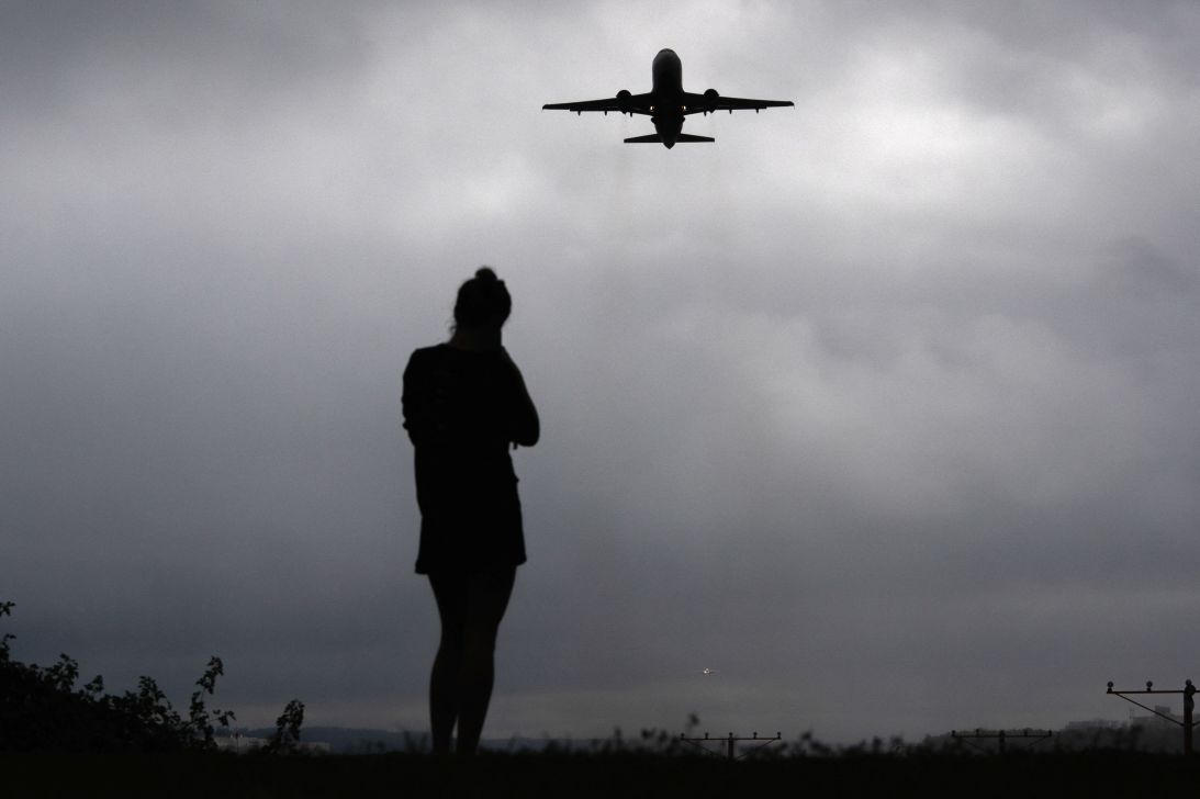 A runner watches as a plane takes off from Reagan Washington National Airport as the US government shutdown continues in Arlington, Virginia, on Wednesday.