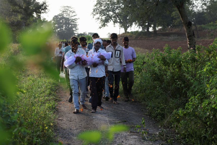 Family members carry the body of Nilesh Suryavanshi's three and a half year old child in a village in Parasia, India on October 9, 2025. The child died after being admitted to a hospital following the consumption of Coldrif cough syrup.