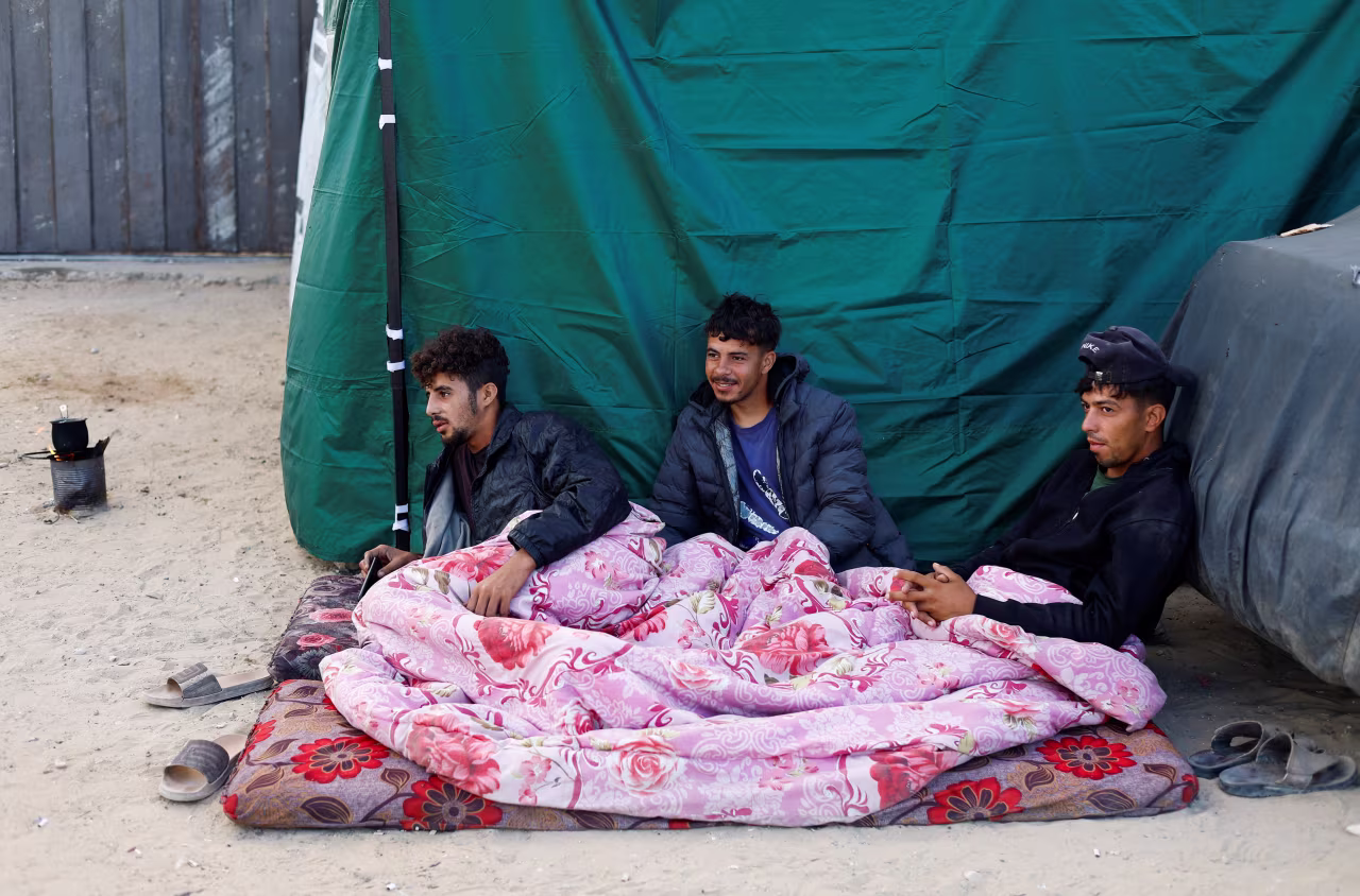 Displaced Palestinians shelter on the side of a road in the central Gaza Strip on October 10.