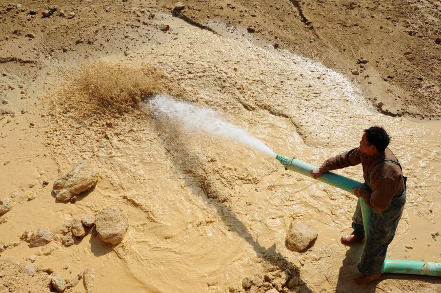 A worker waters the site of a rare earth metals mine at Nancheng county, Jiangxi province on January 16, 2011.