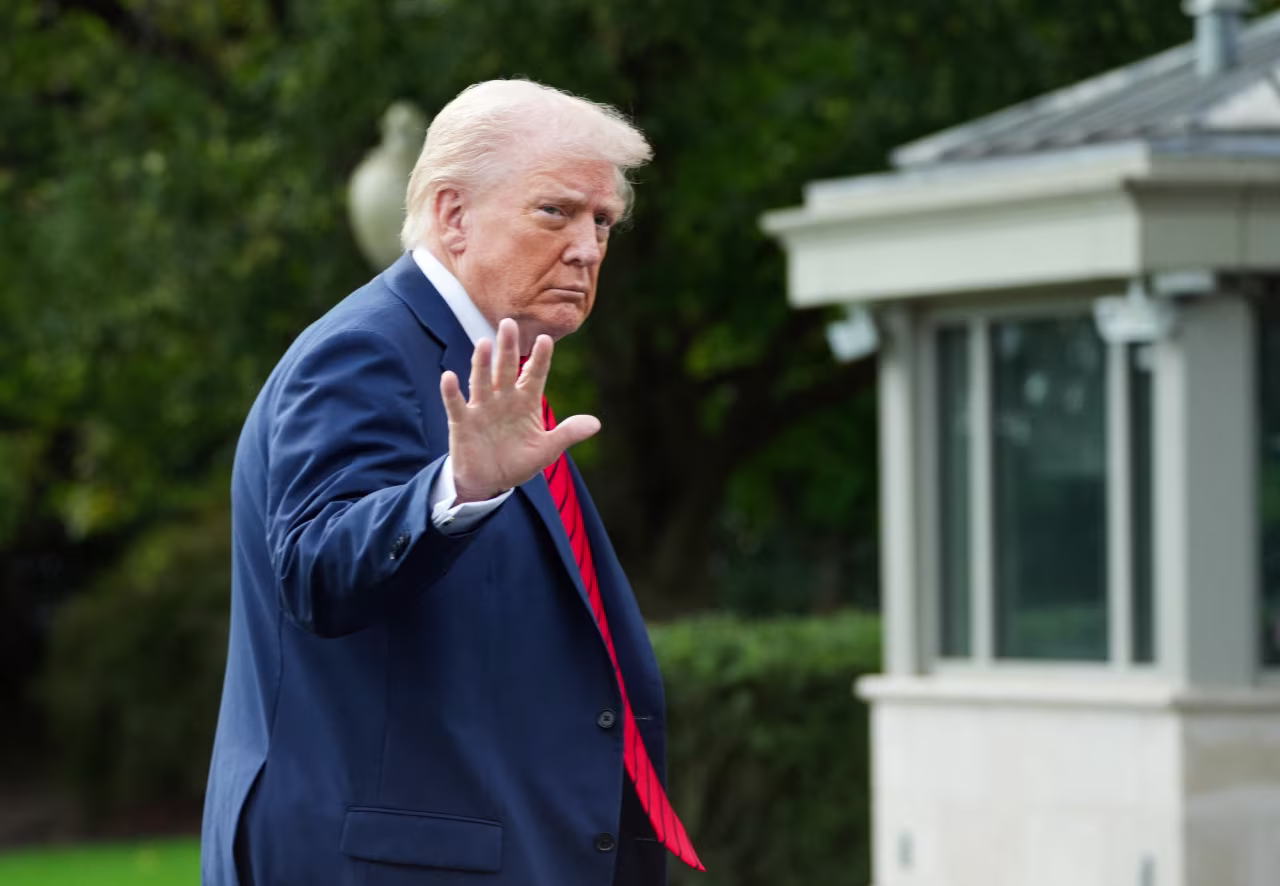 President Donald Trump waves as he arrives at the White House, following a trip to Walter Reed National Military Medical Center on October 10.