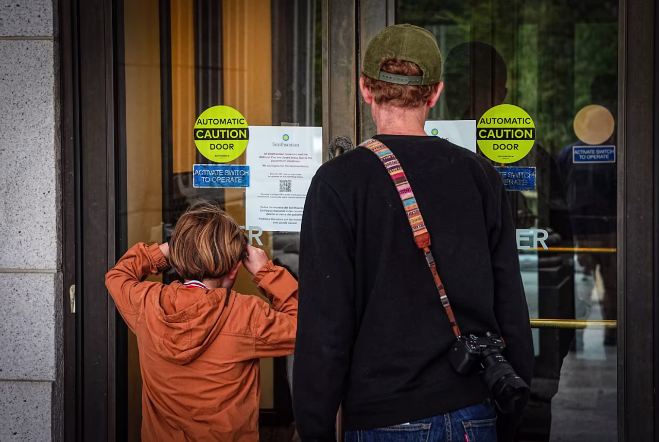 A child peers into the Smithsonian National Museum of Natural History, which is closed due to the continuing U.S. government shutdown in Washington, DC on Sunday.