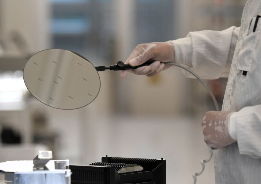 An employee works with a wafer in a production line of Dutch semiconductor company Nexperia in Hamburg, Germany on June 27, 2024.