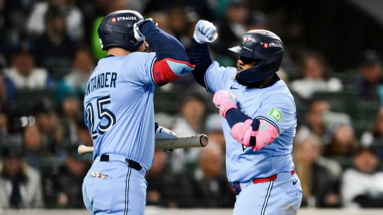 Oct 15, 2025; Seattle, Washington, USA; Toronto Blue Jays first baseman Vladimir Guerrero Jr. (27) celebrates with Toronto Blue Jays right fielder Anthony Santander (25) after hitting a solo home run during the fifth inning against the Seattle Mariners during game three of the ALCS round for the 2025 MLB playoffs at T-Mobile Park. Mandatory Credit: Steven Bisig-Imagn Images