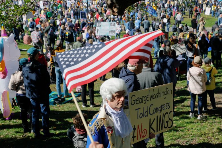 A person dressed as former US President George Washington displays a sign during a "No Kings" protest in Boston on Saturday.