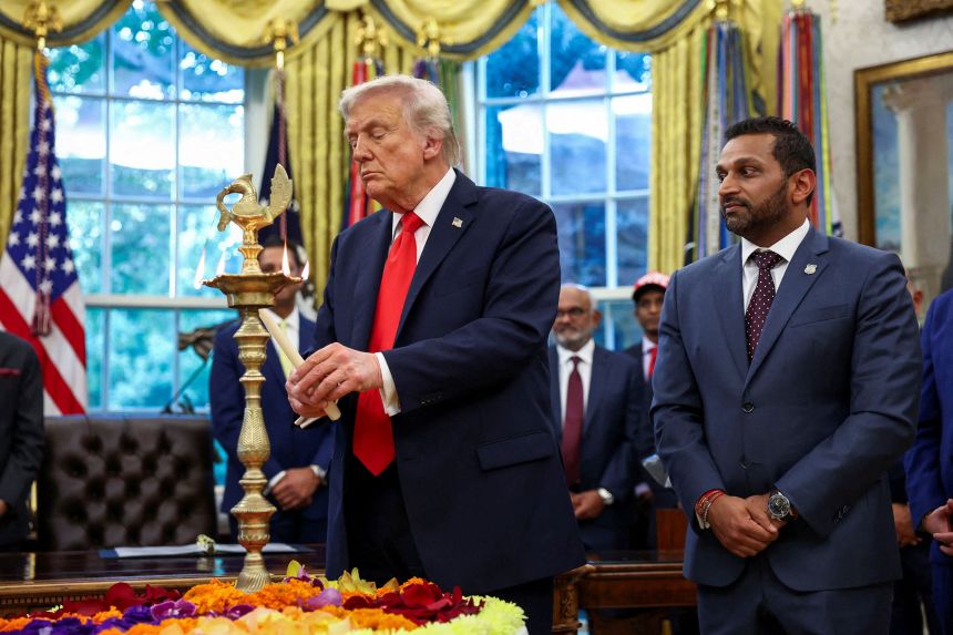 FBI Director Kash Patel looks on as US President Donald Trump lights a candle during a Diwali celebration at the White House on October 21.