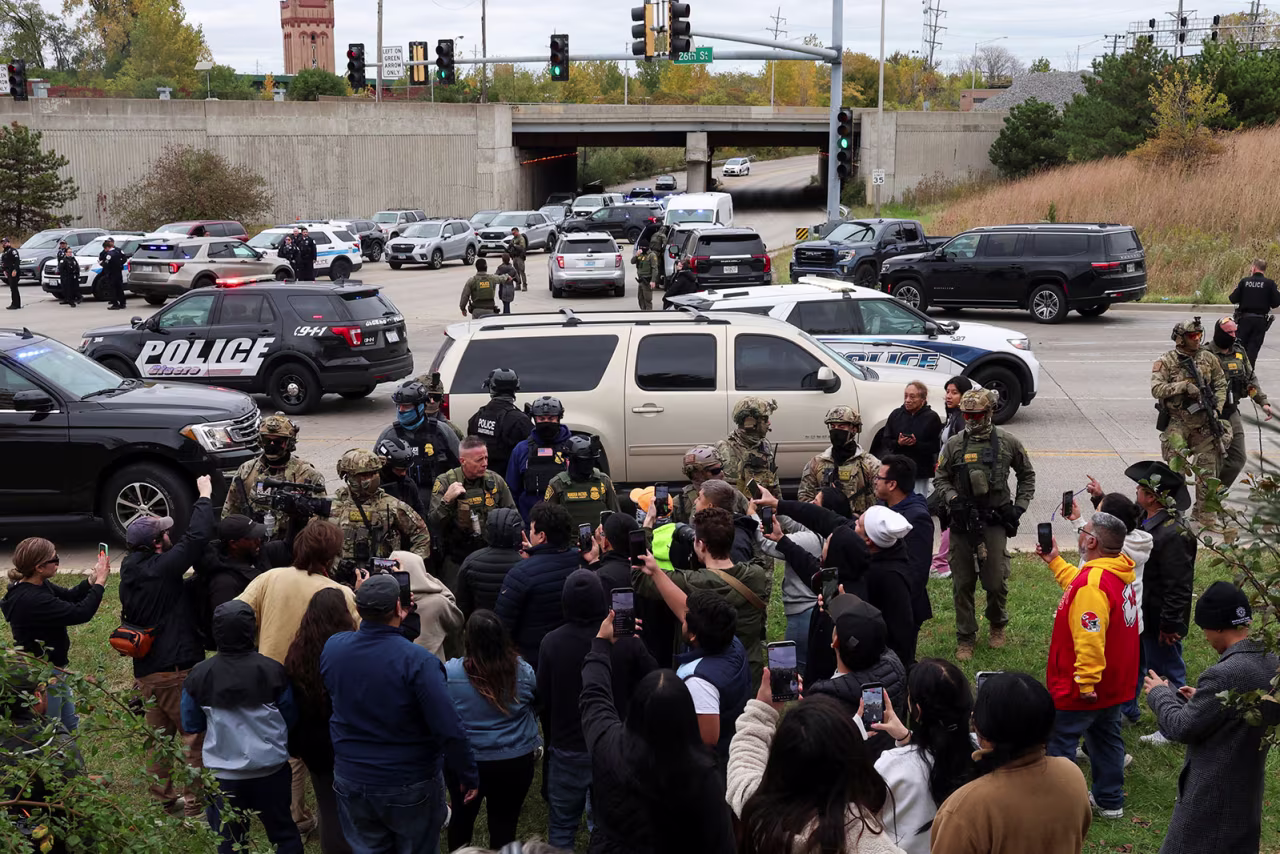 People use their phones to record as they argue with federal agents at an intersection in the Cicero neighborhood during an immigration raid, after President Donald Trump ordered increased federal law enforcement presence to assist in crime prevention, in Chicago, Illinois, on Wednesday.