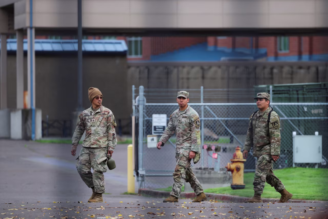 Members of the 49th Military Police Brigade from California, part of the Army National Guard military police brigade, walk across the ground at the Oregon Army National Guard's Camp Withycombe, in Happy Valley, Oregon, on Wednesday.