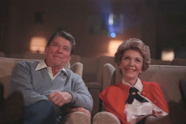 President Ronald Reagan and first lady Nancy Reagan sit in the East Wing family theatre, in 1986.