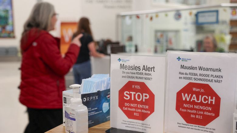 A woman passes near healthy awareness posters related to the measles outbreak during a public health awareness campaign, at the Taber Health Centre, in the largely Mennonite community of Taber, Alberta, Canada, October 27, 2025. REUTERS/Ahmed Zakot