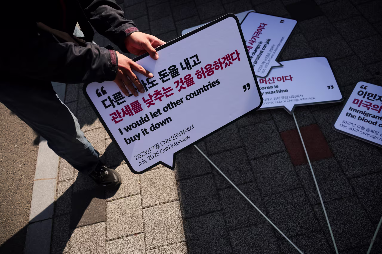 An anti-Trump activist holds a sign as they take part in a rally against US President Donald Trump's visit to South Korea.
