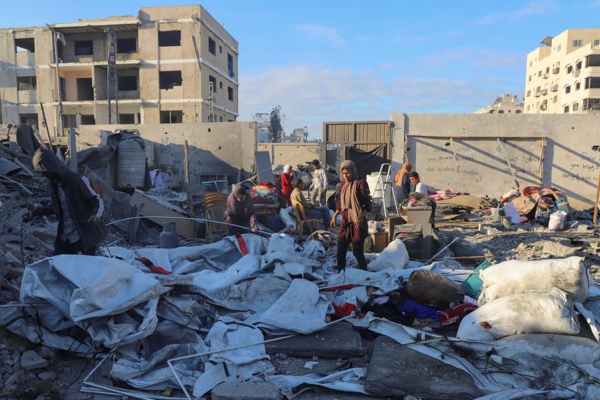 Palestinians inspect the site of an overnight Israeli strike on a house, in Gaza City, on October 29, 2025.