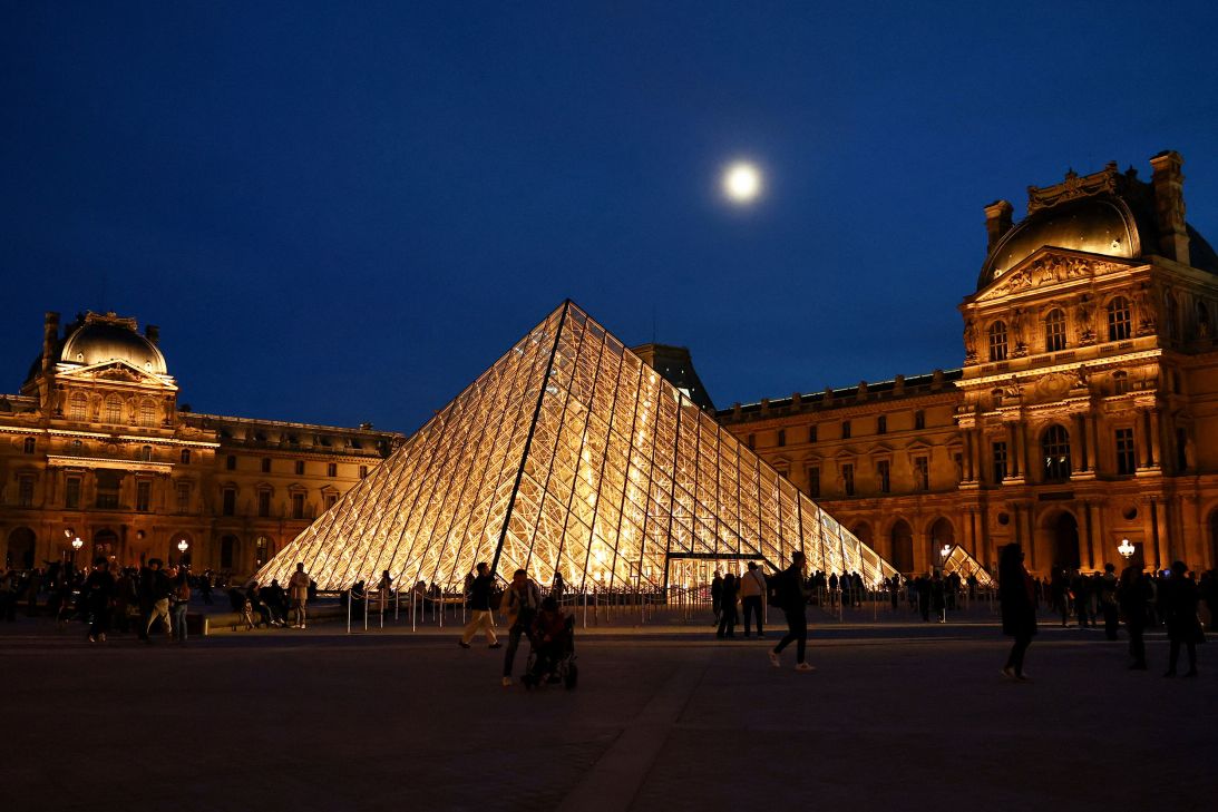 People walk near the glass Pyramid of the Louvre museum in Paris, October 30.