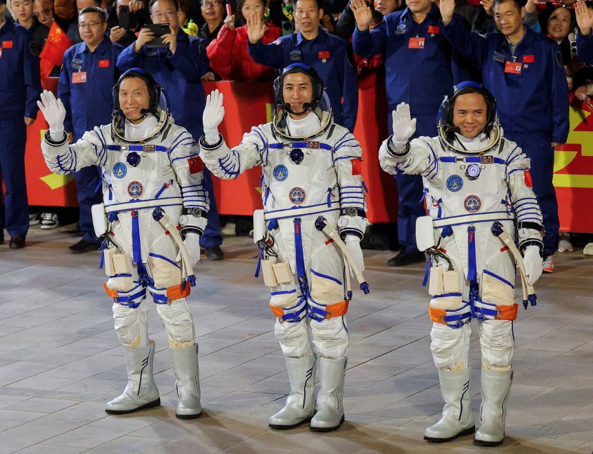 Astronauts Zhang Hongzhang, Wu Fei, and Zhang Lu wave during a see-off ceremony before taking part in the Shenzhou-21 spaceflight mission.