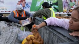 Volunteers Craig Harvey and Randunu Thrikawala place food items in a truck bed during a mobile food distribution at Cedar Creek High School, as nearly 42 million Americans face a potential lapse in Supplemental Nutrition Assistance Program (SNAP) benefits, known as food stamps, due to the second-longest U.S. government shutdown, in Cedar Creek, Texas, U.S., November 1, 2025. REUTERS/Kaylee Greenlee     TPX IMAGES OF THE DAY     