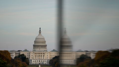 The dome of the US Capitol is reflected in a window as people visit the Washington Monument on November 2.