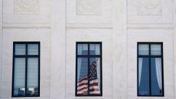 A U.S. flag is reflected on a window of the U.S. Supreme Court, as its justices are set to hear oral arguments on U.S. President Donald Trump's bid to preserve sweeping tariffs after lower courts ruled that Trump overstepped his authority, in Washington, D.C., U.S., November 5, 2025. REUTERS/Nathan Howard TPX IMAGES OF THE DAY