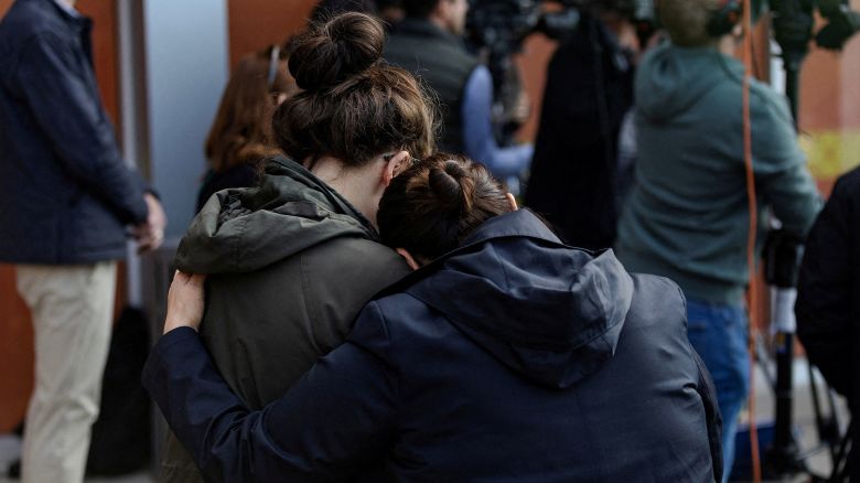 Two parents embrace each other outside of the Rayito De Sol Spanish Immersion Daycare and Pre-School in Chicago, where federal agents conducted an immigration raid that ended in a teacher being detained, on November 5, 2025.