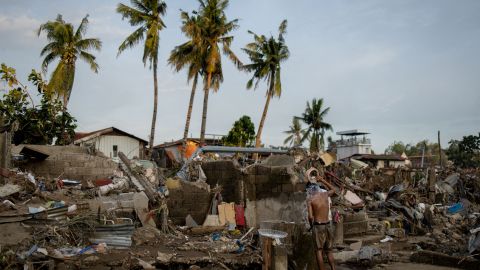 A man takes a bath amid the remains of a community where houses were swept in the floods brought on by Typhoon Kalmaegi in Talisay, Cebu, Philippines on November 6, 2025.