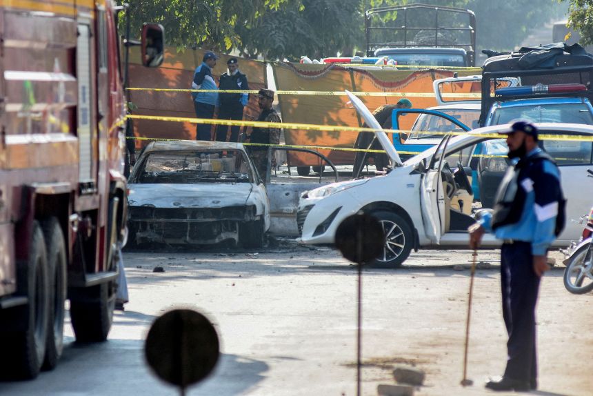 Police officers stand at the scene of an explosion outside a court building in Islamabad on Tuesday.