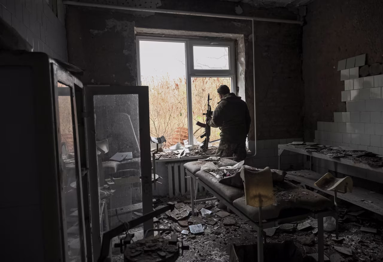 A Ukrainian serviceman observes an area from a hospital damaged by Russian military strikes in the frontline town of Orikhiv, amid Russia’s attack on Ukraine, in Zaporizhzhia region, Ukraine, November 13, 2025.