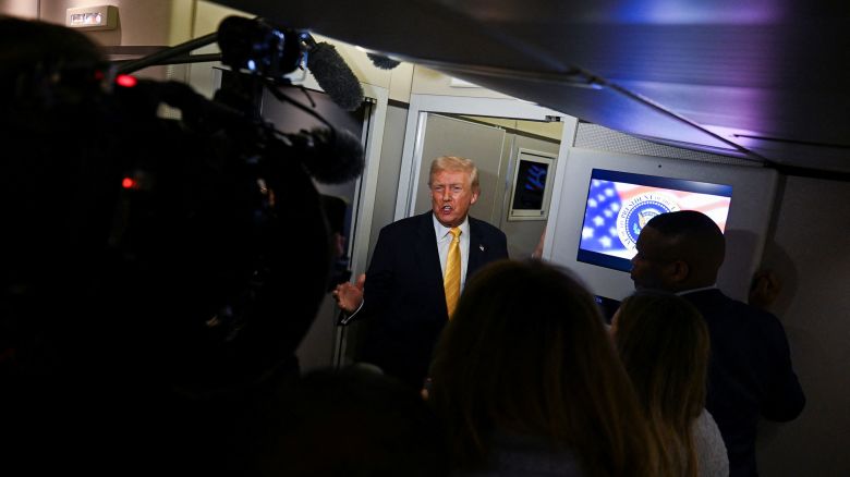 President Donald Trump talks to members of the press on board Air Force One en route to Florida, on November 14.