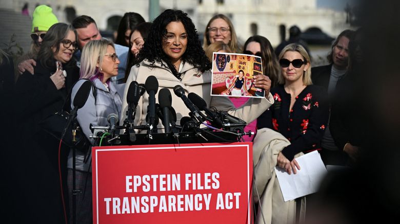 Survivor Lisa Phillips holds up her picture as she speaks during a press conference on the Epstein Files Transparency Act ahead of a House vote on the release of files related to the late convicted sex offender Jeffrey Epstein, on Capitol Hill in Washington, DC on Tuesday.