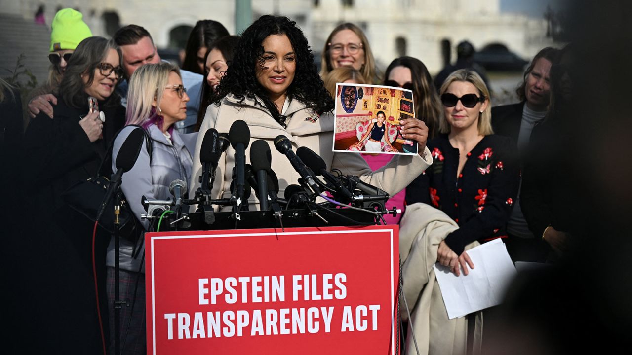 Survivor Lisa Phillips holds up her picture as she speaks during a press conference on the Epstein Files Transparency Act ahead of a House vote on the release of files related to the late convicted sex offender Jeffrey Epstein, on Capitol Hill in Washington, DC on Tuesday.