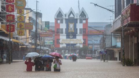 People wade through a flooded area in Hat Yai district, Songkhla, Thailand, November 22, 2025.