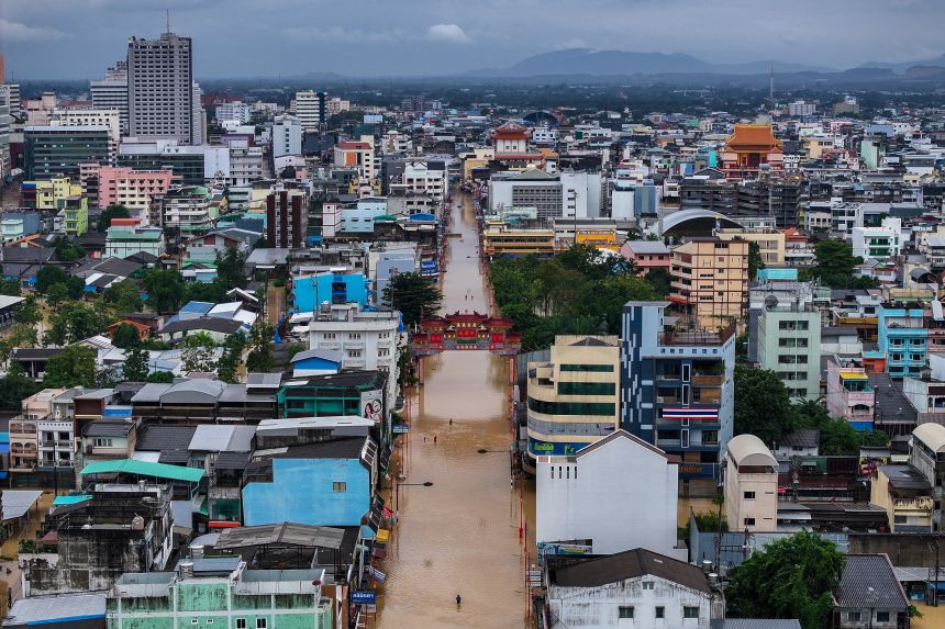 A drone view shows people wading through a flooded area in Hat Yai, Thailand, on November 23, 2025.