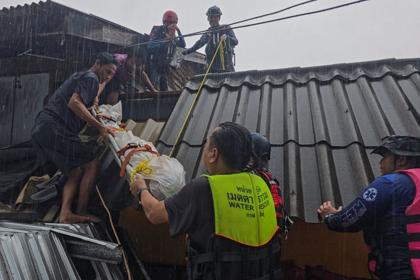 Rescue teams carry the body of a victim out of their partially-submerged home in Hat Yai, southern Thailand, on November 24, 2025.