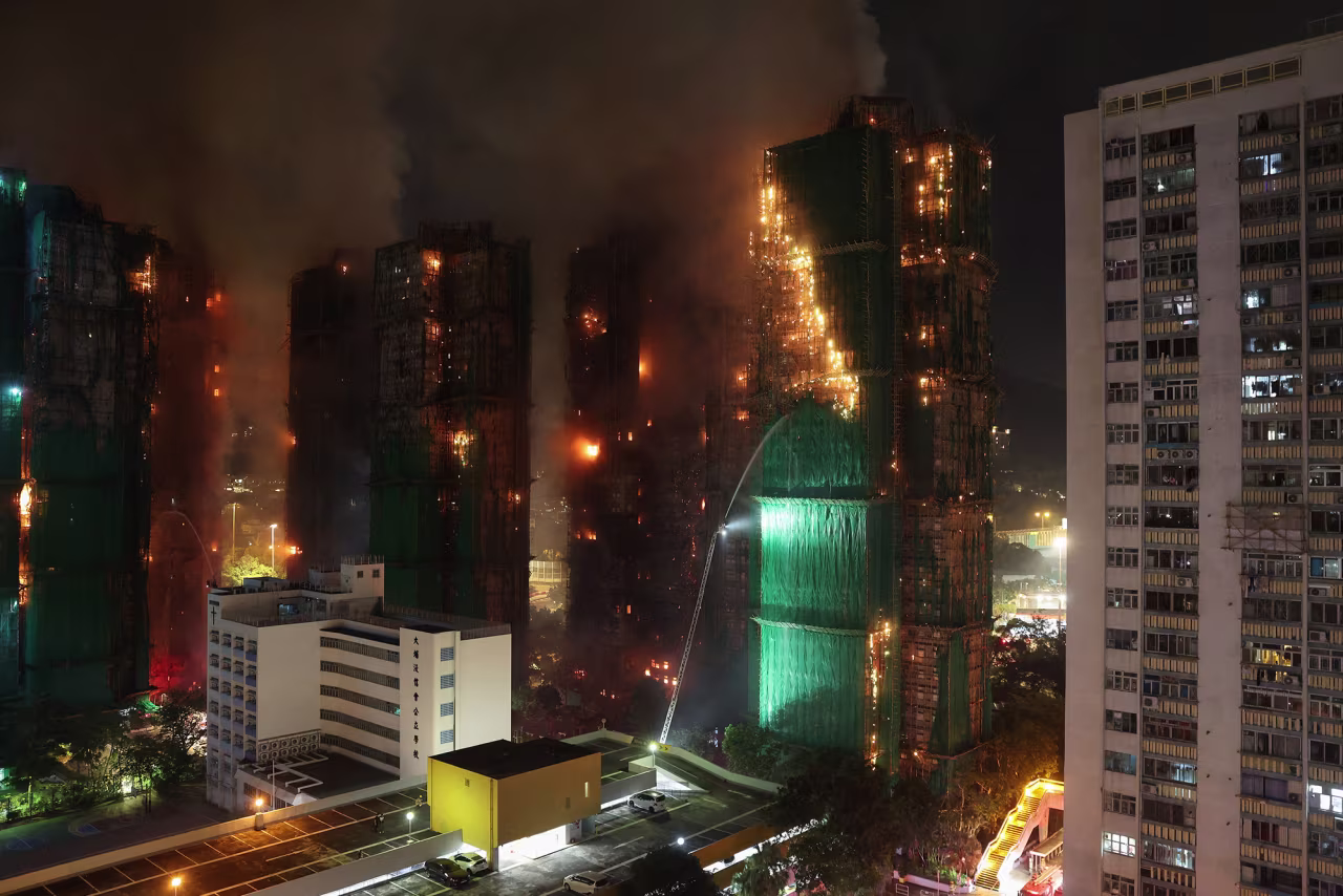 Firefighters work to extinguish flames as fire burns bamboo scaffolding across multiple buildings at Wang Fuk Court housing estate, in Tai Po, Hong Kong, on Wednesday.