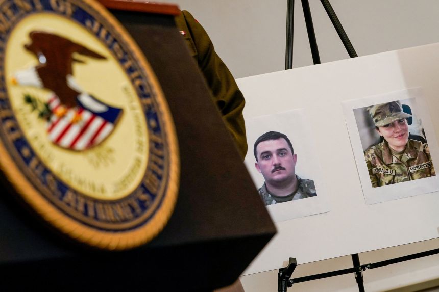 Pictures of Andrew Wolfe and Sarah Beckstrom are displayed at a news conference in Washington, DC, on Thursday.