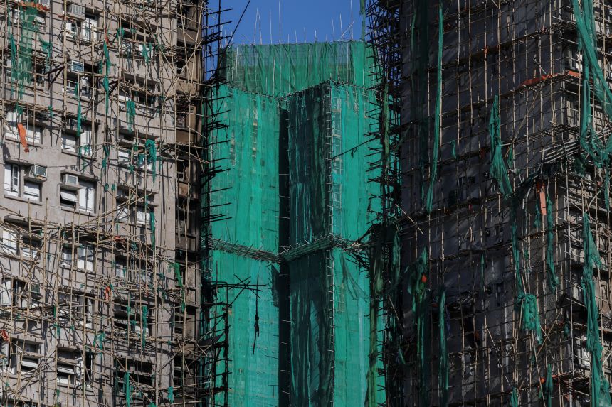 Wang Chi House stands unaffected between charred remains of fire-damaged residential blocks at the Wang Fuk Court housing complex