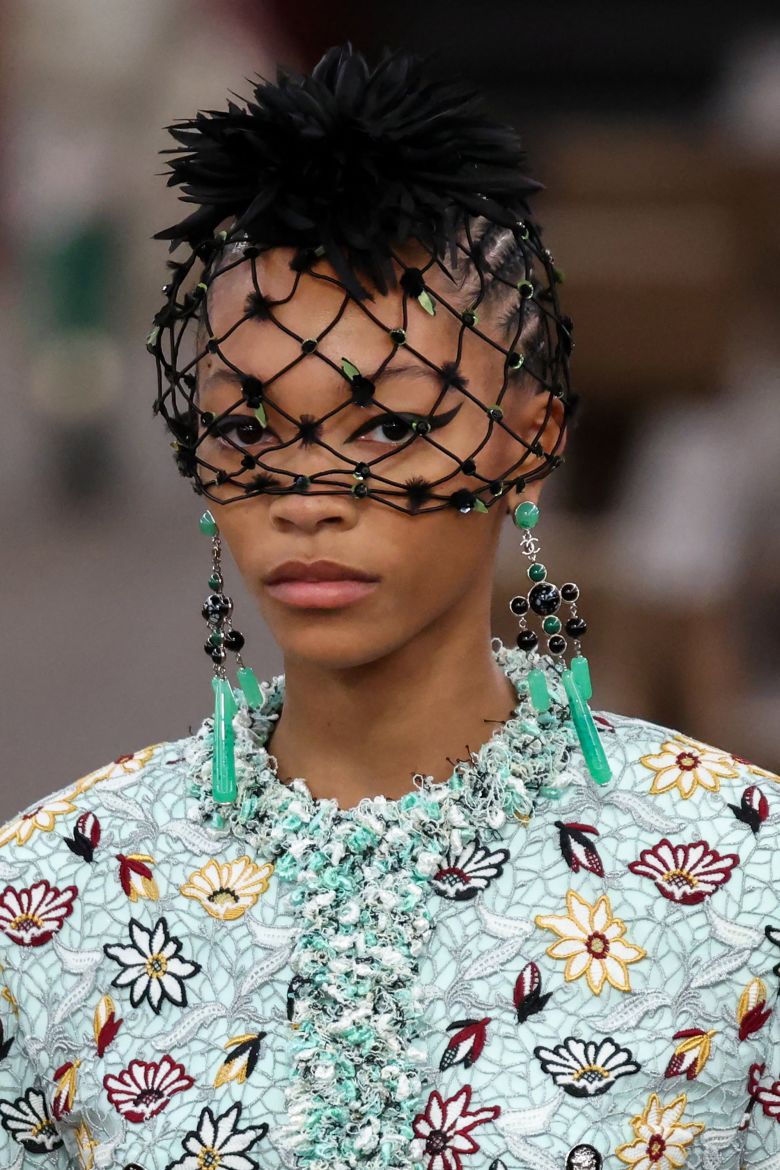 A close-up of a model walking the Chanel Metiers d'art 2026 show in New York.