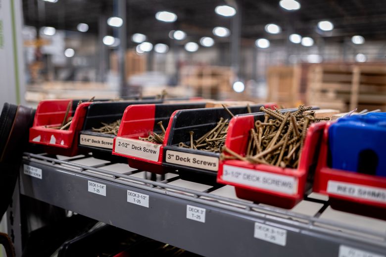 Decking screws are organized by size inside of the factory.