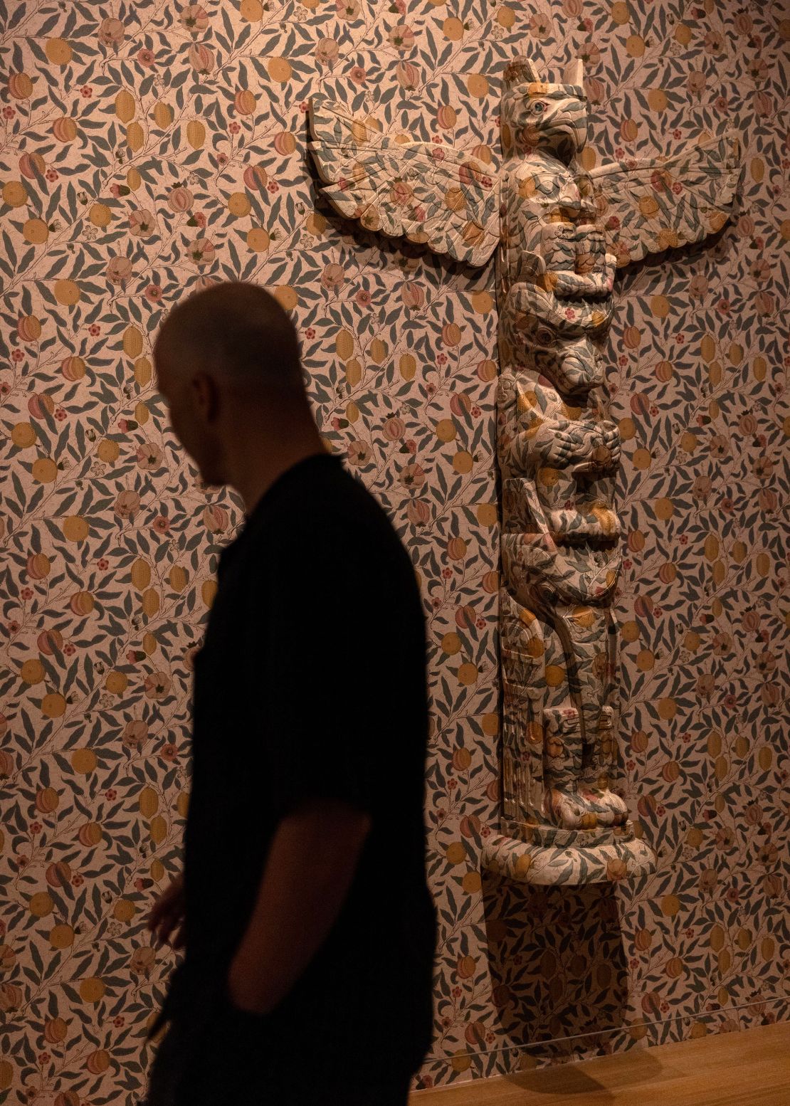 A visitor touring the exhibit walks past Nicholas Galanin's 