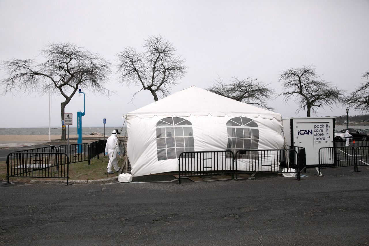 A health worker waits for new patients a drive-thru coronavirus testing station at Cummings Park in Stamford, Connecticut, on March 23.