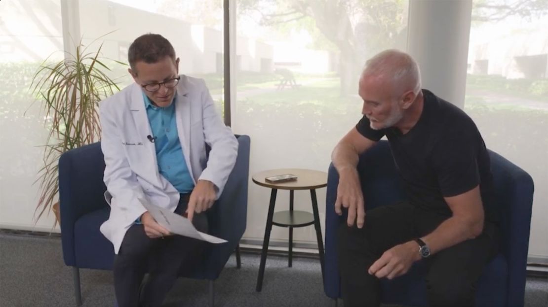 Dr. Richard Isaacson, left, discusses the test results with Simon Nichols, participant number 34 in the clinical trial.