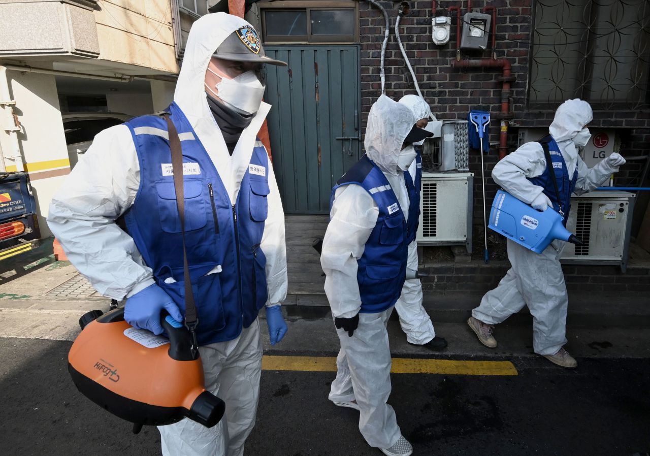 Workers spray disinfectant at a market in Seoul on Monday.